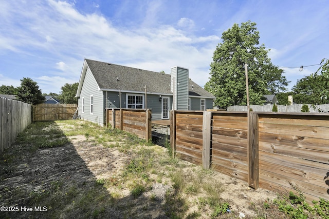711 Glenarthur Dr, Wilmington, NC 28412 - back of property with a fenced backyard, a chimney, and a shingled roof