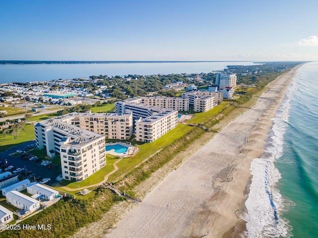 birds eye view of property featuring a water view and a beach view