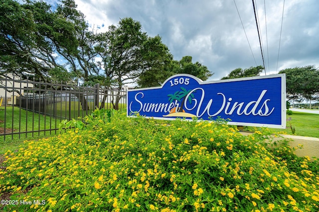 community sign featuring a yard and fence