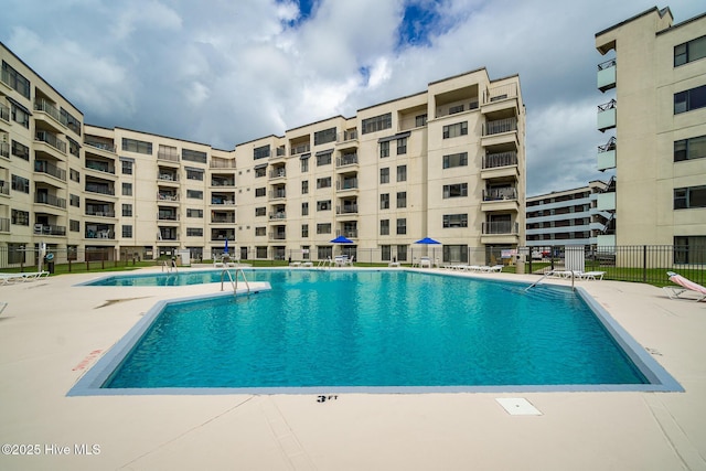 pool with a patio and fence
