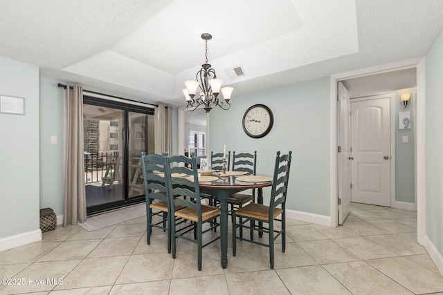 dining space with baseboards, visible vents, light tile patterned flooring, a chandelier, and a raised ceiling