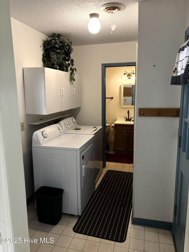 16 Bayberry Cir, Calabash, NC 28467 - laundry area featuring cabinet space, washer and clothes dryer, a textured ceiling, and light tile patterned floors