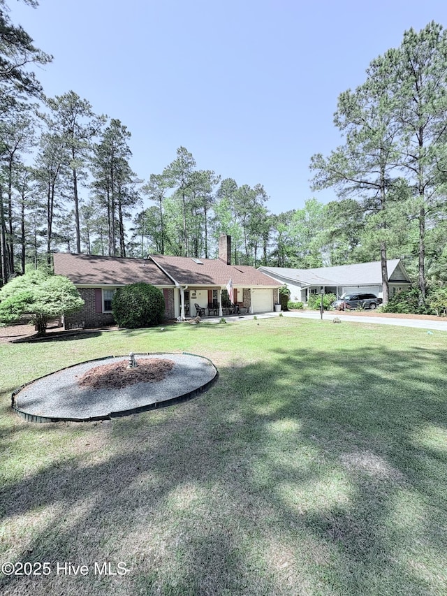 16 Bayberry Cir, Calabash, NC 28467 - rear view of house featuring a garage, a chimney, and a yard