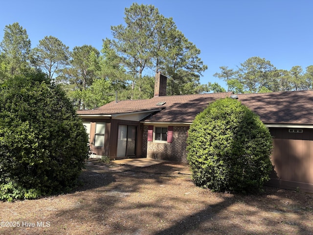 16 Bayberry Cir, Calabash, NC 28467 - view of side of home with a chimney, a shingled roof, and brick siding