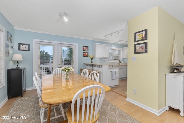 104 Island Quay Ct, Atlantic Beach, NC 28512 - dining space with track lighting, light wood finished floors, baseboards, french doors, and crown molding