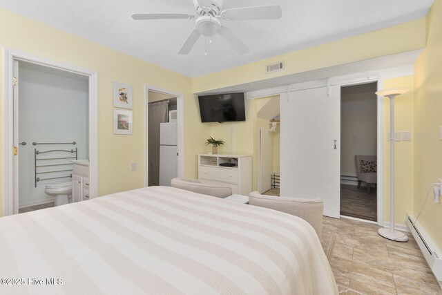104 Island Quay Ct, Atlantic Beach, NC 28512 - bedroom featuring freestanding refrigerator, a baseboard radiator, a closet, ensuite bath, and baseboards