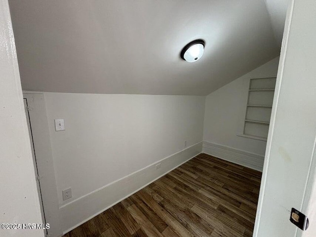 additional living space featuring built in features, wood finished floors, lofted ceiling, and baseboards