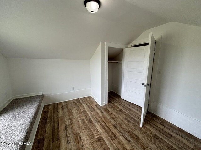 bonus room featuring baseboards, wood finished floors, and lofted ceiling