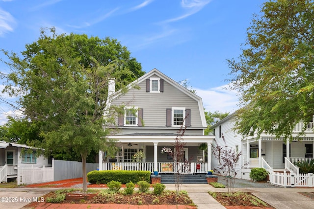 view of front facade with a porch, a ceiling fan, and fence