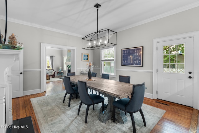 dining room featuring plenty of natural light, ornamental molding, and wood-type flooring