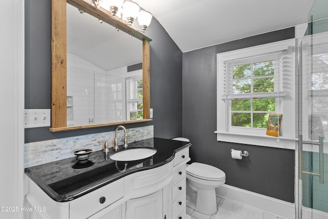 bathroom with an enclosed shower, vanity, baseboards, toilet, and lofted ceiling
