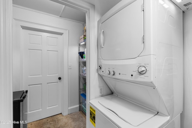 laundry room featuring baseboards, laundry area, stacked washer / dryer, and light colored carpet