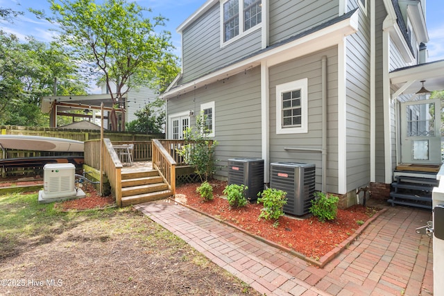exterior space featuring fence, central AC unit, and a deck