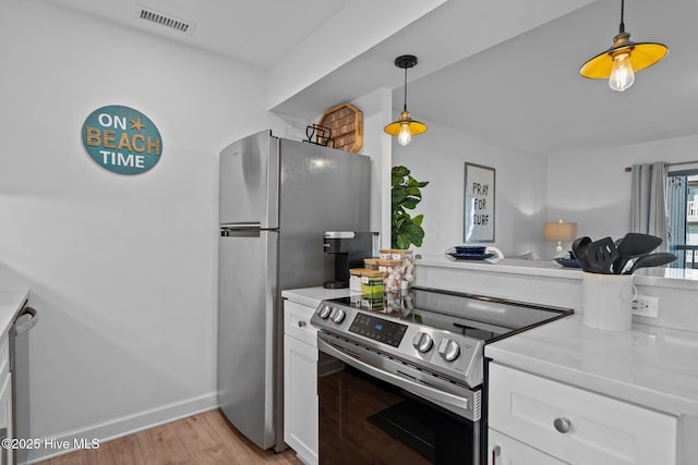 kitchen featuring light wood-style flooring, stainless steel appliances, white cabinets, visible vents, and light countertops