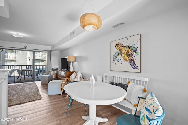 dining space with visible vents and wood finished floors
