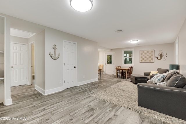 living area with light wood finished floors, baseboards, and visible vents