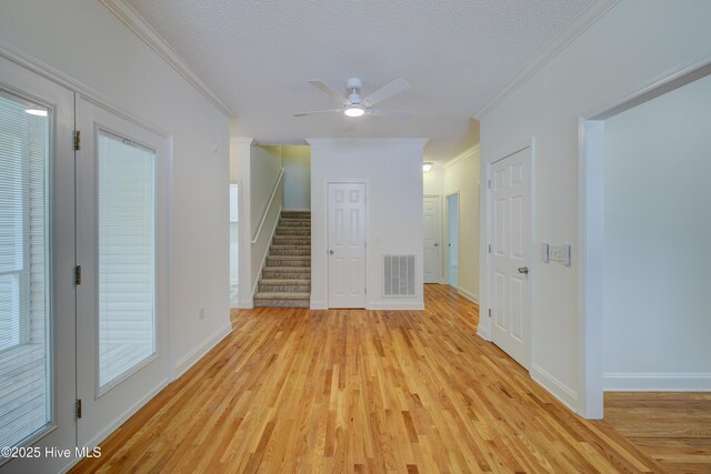1708 N County Dr, Castle Hayne, NC 28429 - empty room with crown molding, light wood-style flooring, a ceiling fan, stairs, and baseboards