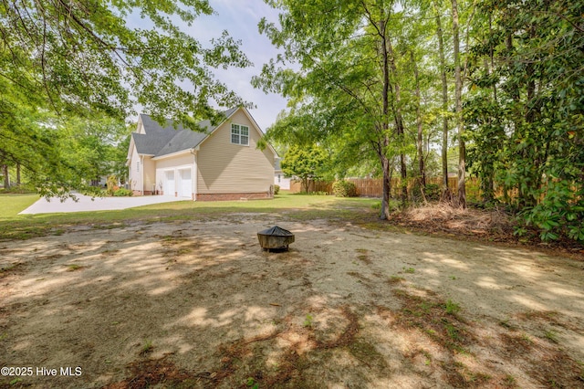 1708 N County Dr, Castle Hayne, NC 28429 - view of yard featuring an outdoor fire pit, an attached garage, and concrete driveway