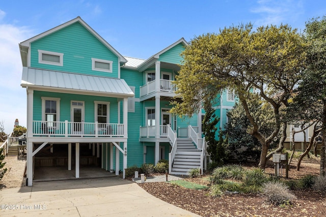 449 Maritime Pl, Pine Knoll Shores, NC 28512 - raised beach house with covered porch, driveway, stairs, a standing seam roof, and a carport