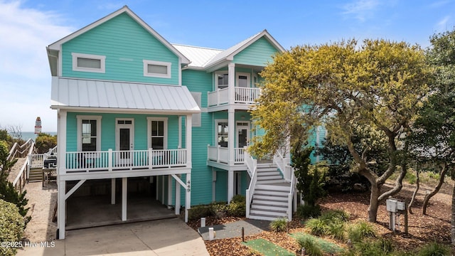 449 Maritime Pl, Pine Knoll Shores, NC 28512 - coastal home featuring covered porch, a carport, stairs, a standing seam roof, and metal roof