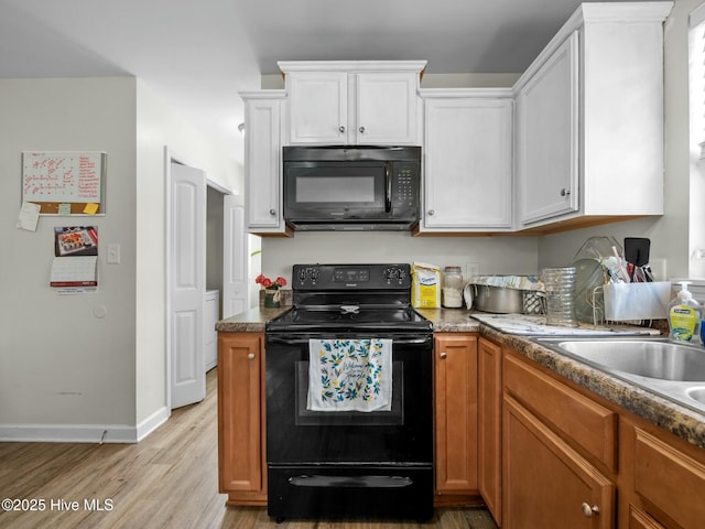 kitchen with light wood-type flooring, a sink, baseboards, white cabinets, and black appliances
