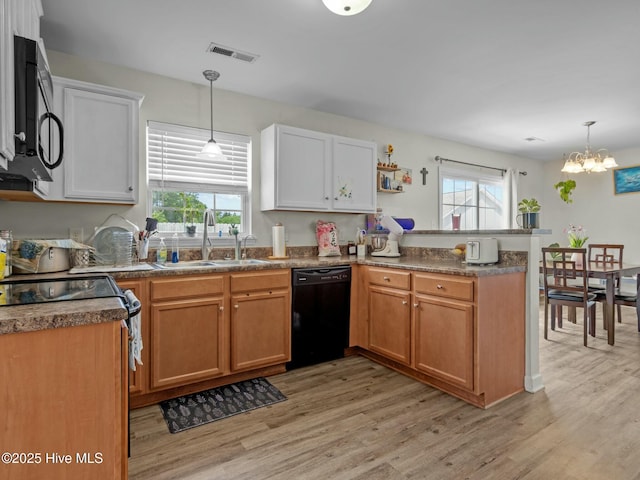 kitchen with visible vents, a sink, black appliances, a peninsula, and a wealth of natural light