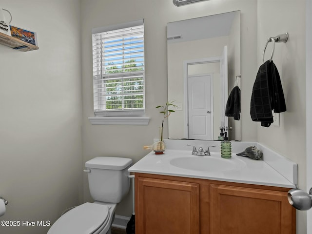 half bath with vanity, visible vents, and toilet