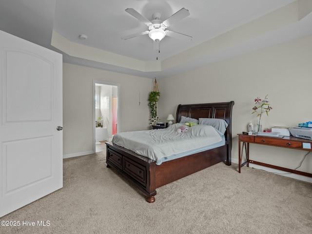 bedroom featuring a ceiling fan, baseboards, light carpet, and a tray ceiling