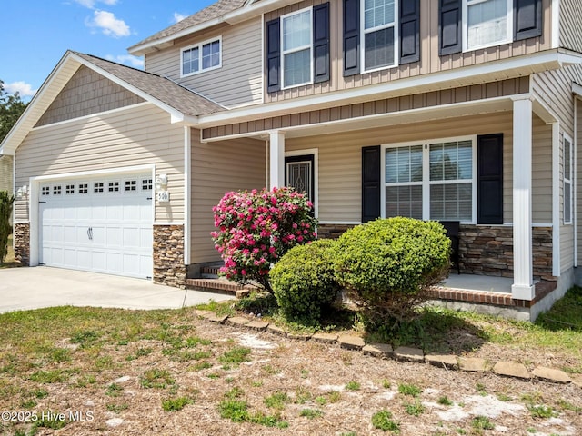 view of front of house featuring a porch, driveway, a garage, a shingled roof, and stone siding