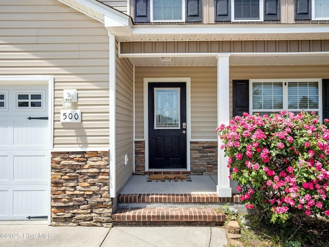 doorway to property featuring covered porch and stone siding