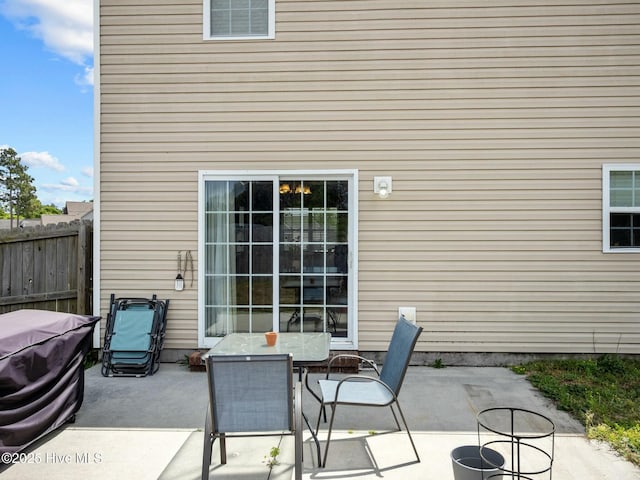 view of patio featuring outdoor dining area and fence