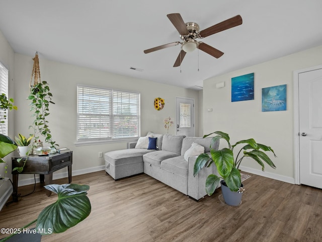 living room featuring baseboards, ceiling fan, wood finished floors, and visible vents