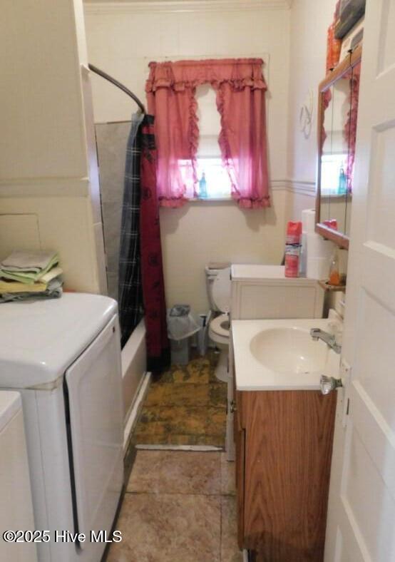 full bath featuring toilet, washing machine and clothes dryer, vanity, and shower / bath combo