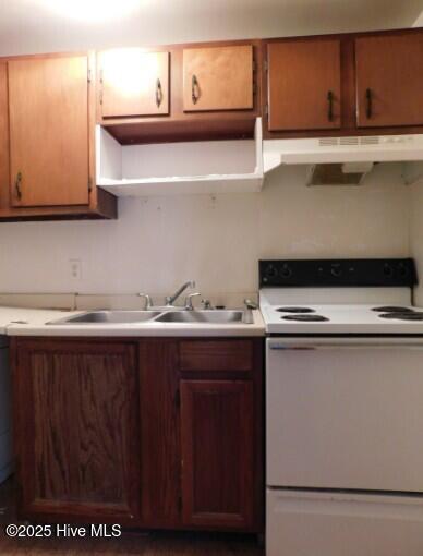 kitchen featuring light countertops, under cabinet range hood, a sink, and electric range