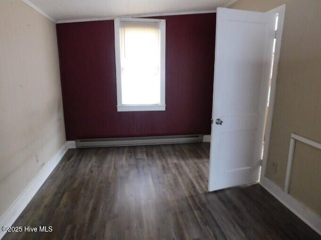 spare room with ornamental molding, baseboards, wood finished floors, and baseboard heating