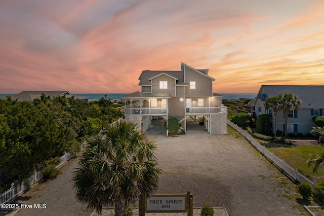 601 Caswell Beach Rd, Caswell Beach, NC 28465 - view of front of house with a carport, driveway, fence, and stairway