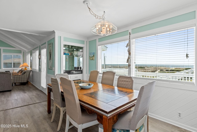 601 Caswell Beach Rd, Caswell Beach, NC 28465 - dining area with lofted ceiling, a healthy amount of sunlight, a chandelier, and light wood-type flooring