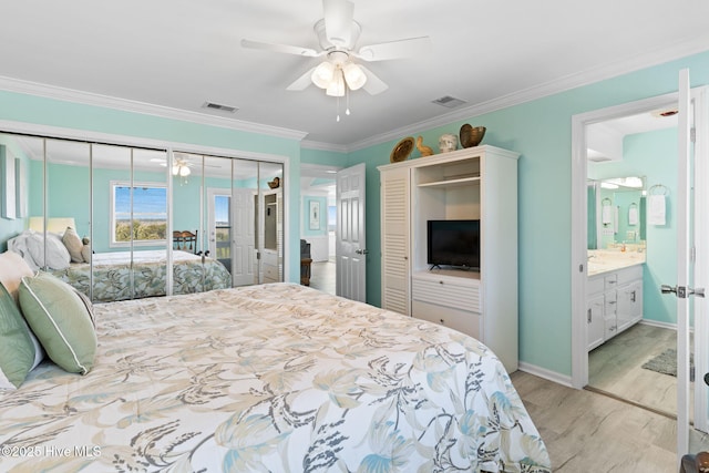601 Caswell Beach Rd, Caswell Beach, NC 28465 - bedroom with two closets, ornamental molding, light wood-style floors, and visible vents