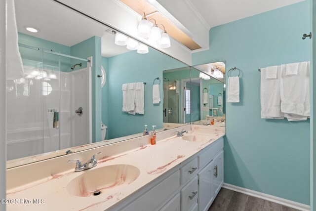 601 Caswell Beach Rd, Caswell Beach, NC 28465 - full bath featuring a shower stall, wood finished floors, double vanity, and a sink