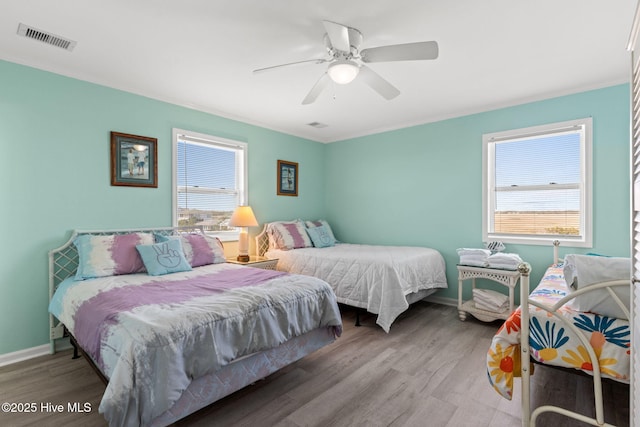 601 Caswell Beach Rd, Caswell Beach, NC 28465 - bedroom featuring wood finished floors, visible vents, baseboards, and ornamental molding