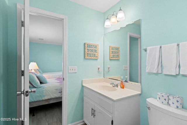 601 Caswell Beach Rd, Caswell Beach, NC 28465 - ensuite bathroom with wood finished floors, toilet, vanity, and connected bathroom