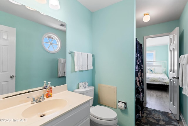 601 Caswell Beach Rd, Caswell Beach, NC 28465 - bathroom featuring toilet, ensuite bathroom, visible vents, wood finished floors, and vanity