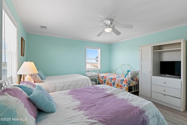 601 Caswell Beach Rd, Caswell Beach, NC 28465 - bedroom with crown molding, wood finished floors, visible vents, and a closet