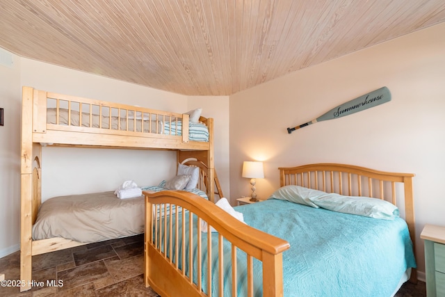 bedroom with wood ceiling and stone finish flooring