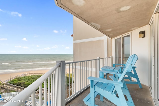 balcony featuring a beach view and a water view