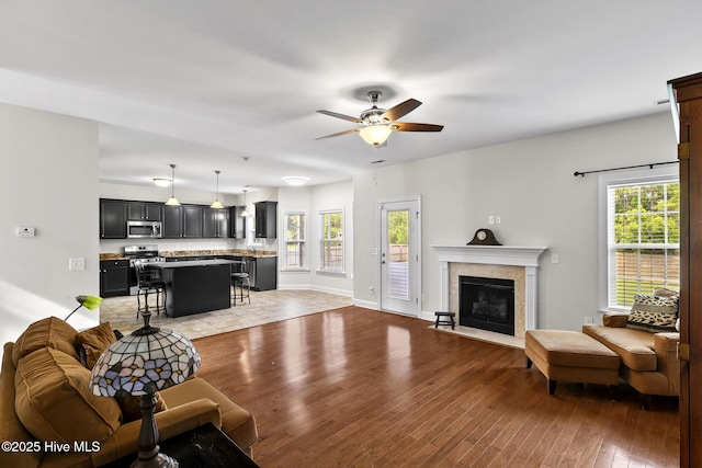 705 Shearwater Ln, Swansboro, NC 28584 - living area featuring light wood-style flooring, ceiling fan, a fireplace, and baseboards
