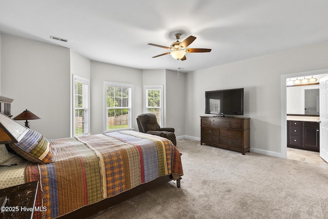 705 Shearwater Ln, Swansboro, NC 28584 - bedroom with light colored carpet, baseboards, ceiling fan, and ensuite bath