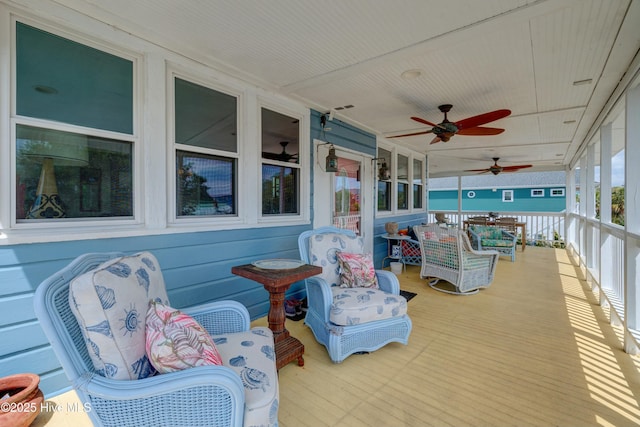 wooden terrace with a porch, ceiling fan, and visible vents