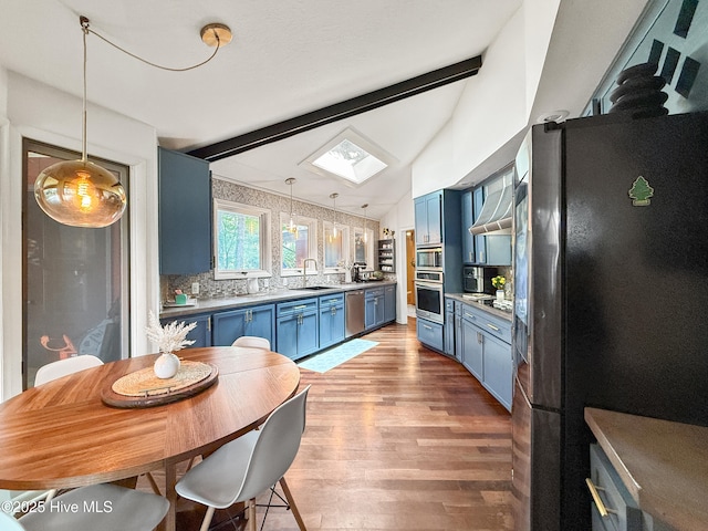40 Inverness Rd, Pinehurst, NC 28374 - kitchen featuring blue cabinets, stainless steel appliances, light wood finished floors, and hanging light fixtures