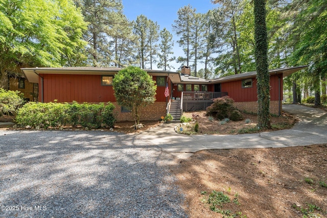 40 Inverness Rd, Pinehurst, NC 28374 - ranch-style home featuring stairs, a deck, driveway, and a chimney